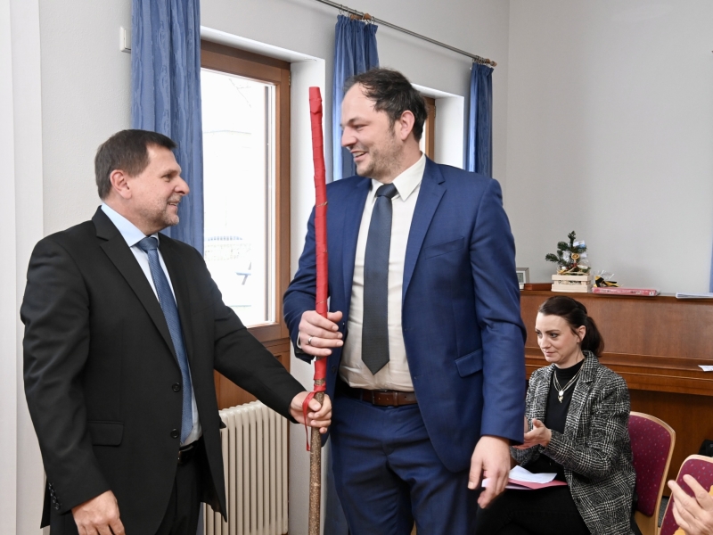 Zwei Personen mit Stab