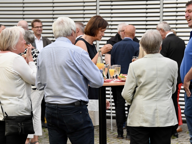Personen unterhalten sich aneinem Stehtisch