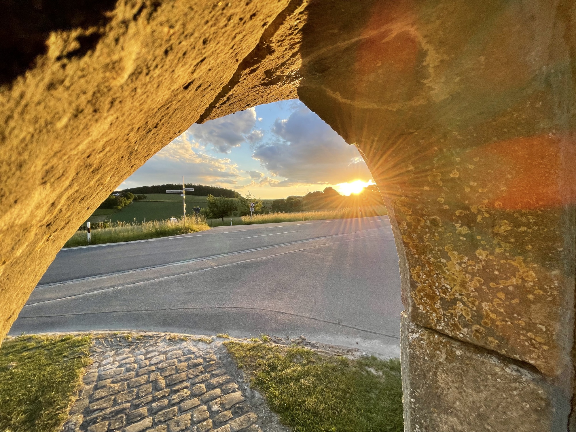 Blick durch ein Tor auf Sonnenuntergang