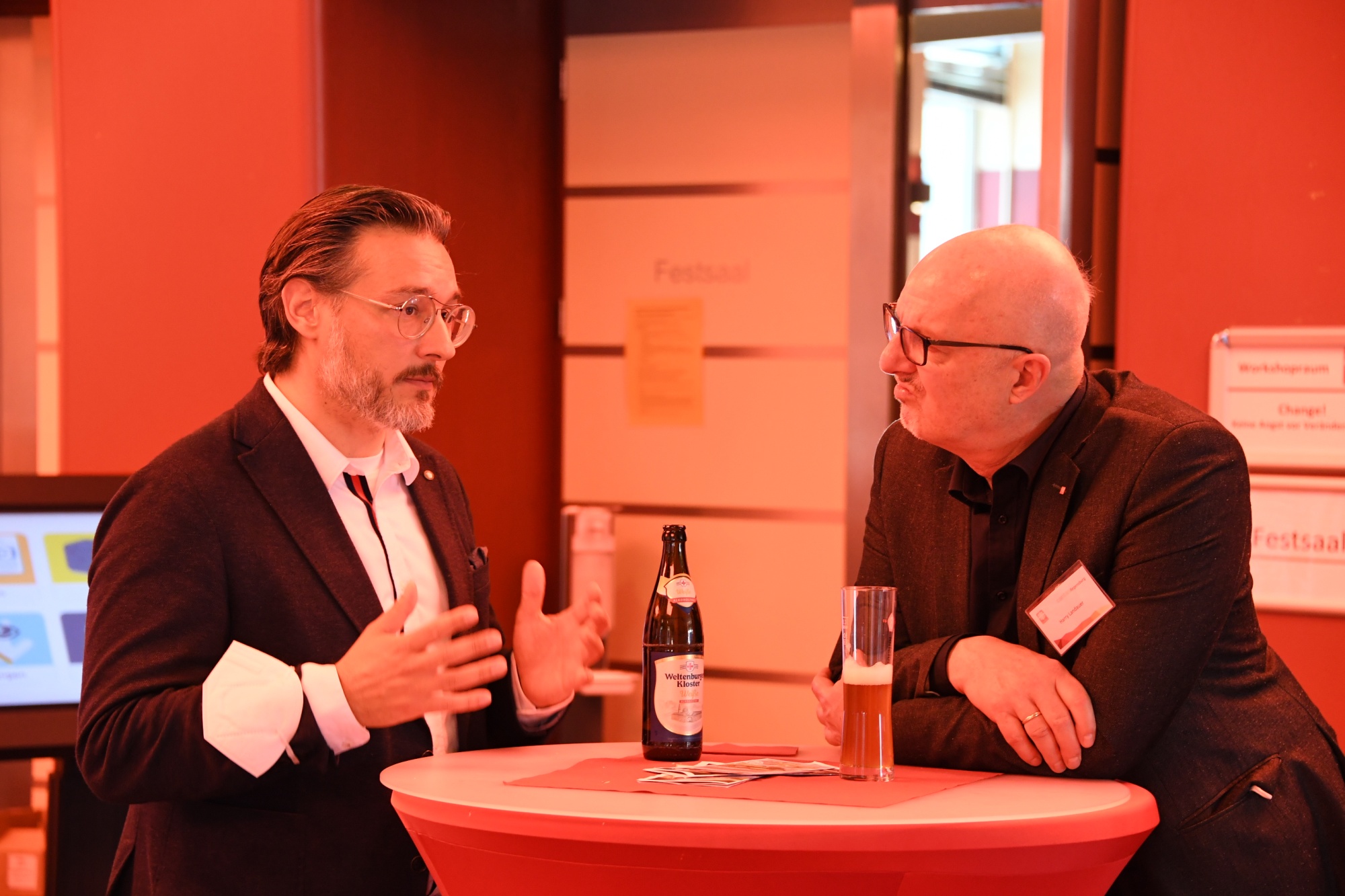 Zwei personen an stehtisch im Gespräch