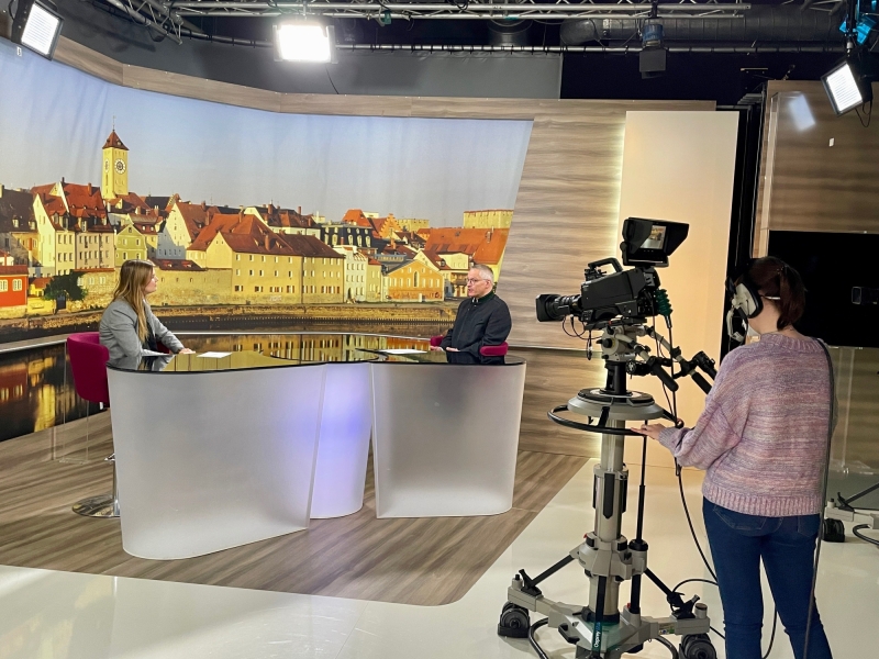 Zwei Personen sitzen sich im Studio gegen&uuml;ber und f&uuml;hren offenbar ein Gespr&auml;ch.