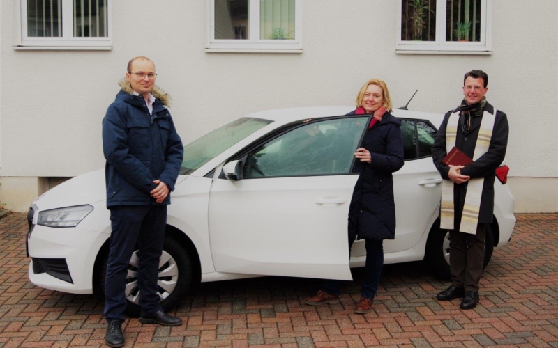 3 Personen vor einem Auto