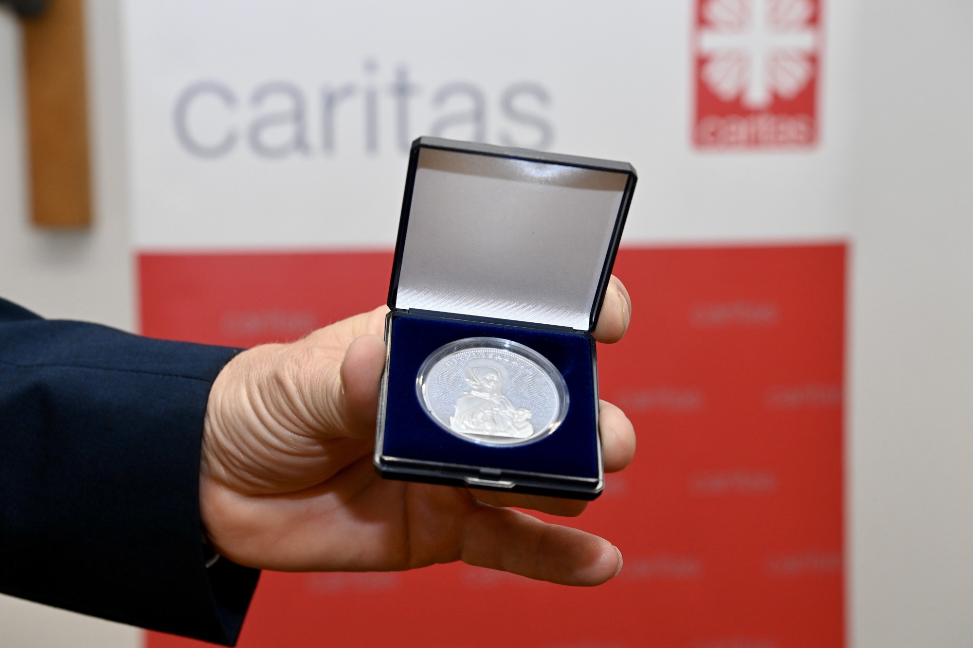 Hand zeigt Medaille