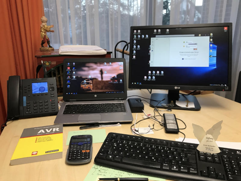 Ein Schreibtisch mit Monitor, Tastatur und B&uuml;roausstattung. Auf dem Bildschirm ist eine ge&ouml;ffnete Anwendung zu sehen.