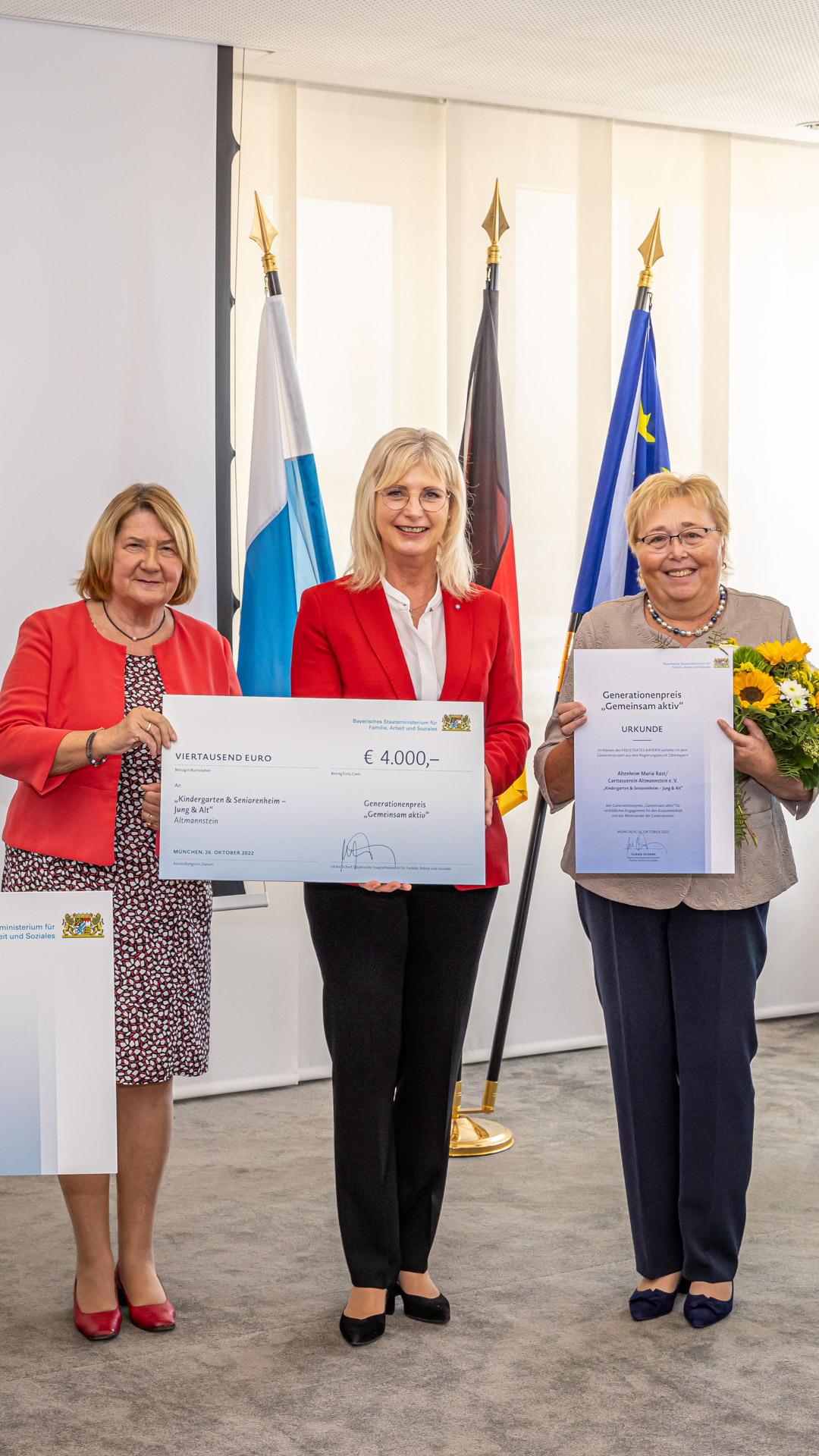 Drei Personen mit Urkunden