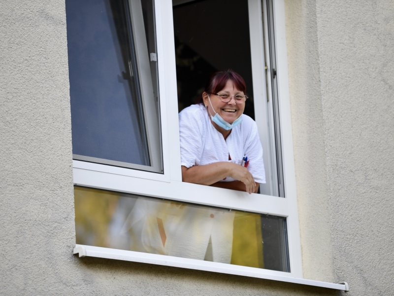 Frau schaut aus Fenster