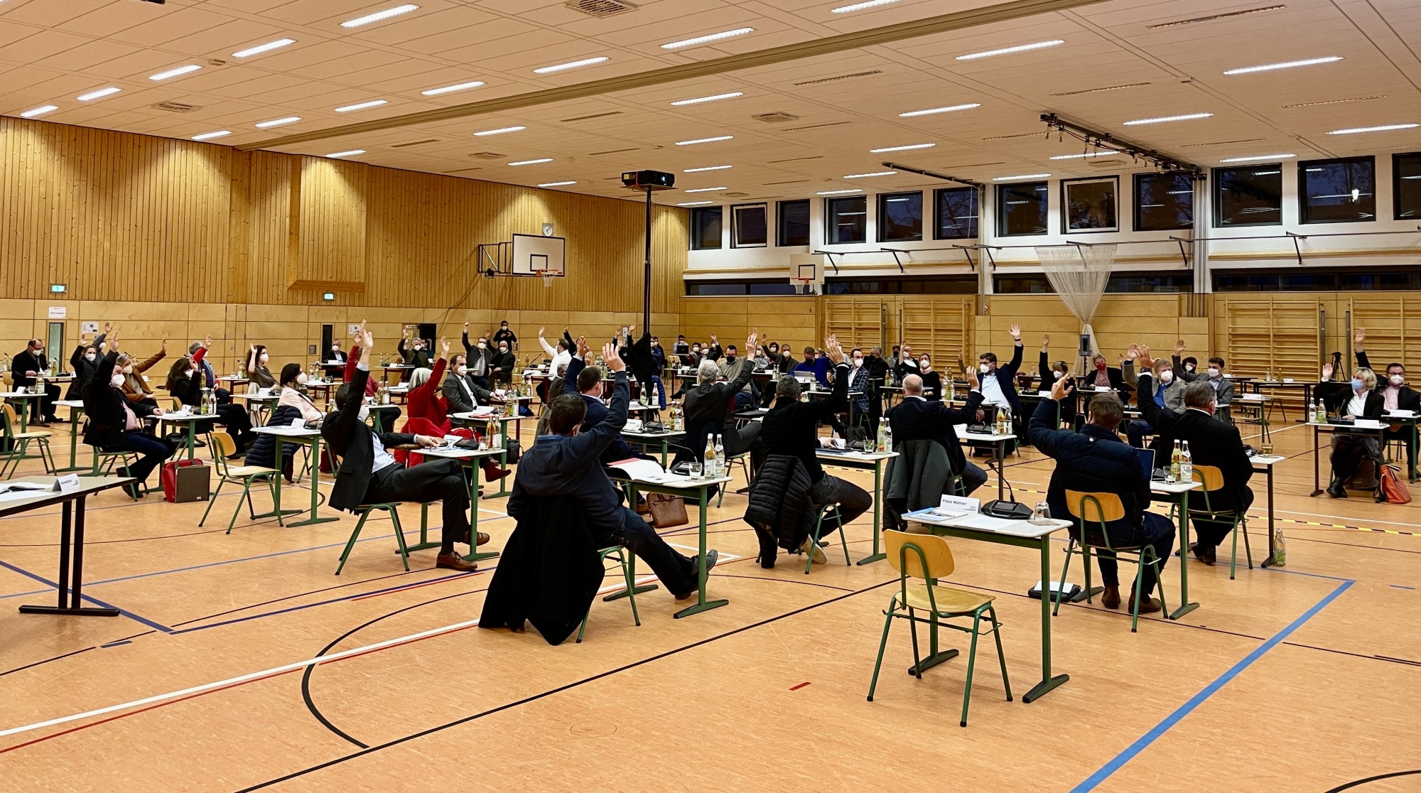 Ein großer Saal mit vielen sitzenden Personen an Tischen. Die Anordnung wirkt wie eine offizielle Versammlung oder Abstimmung.