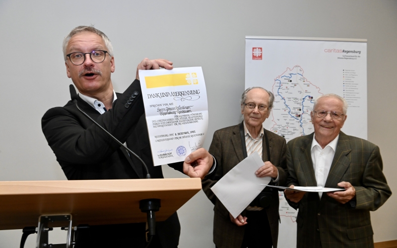 Redner zeigt Dokument in Kamera