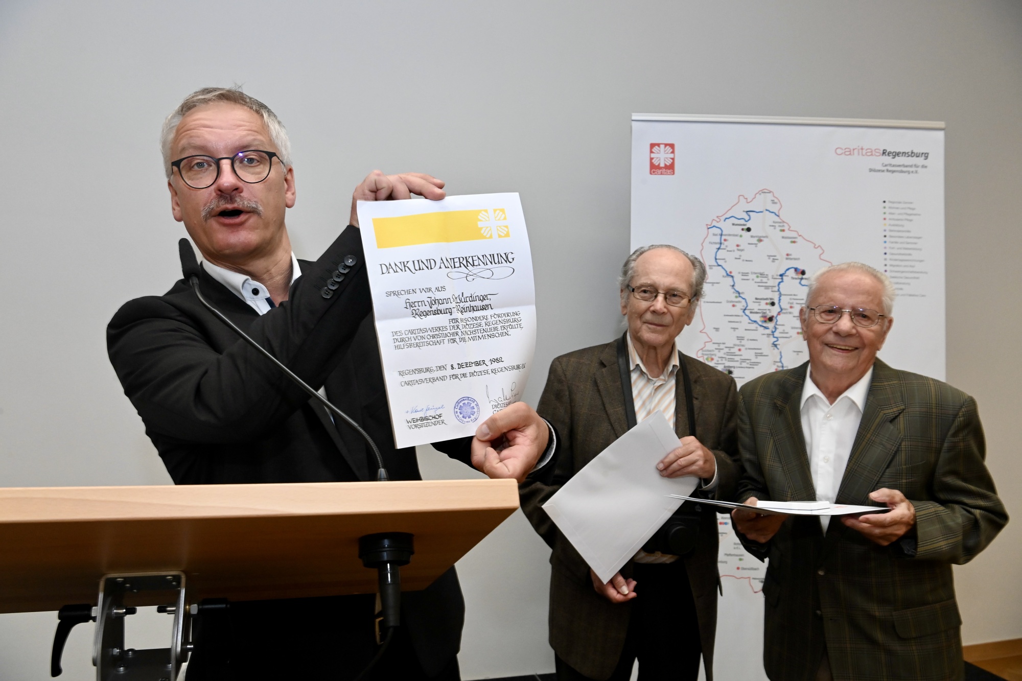Redner zeigt Dokument in Kamera