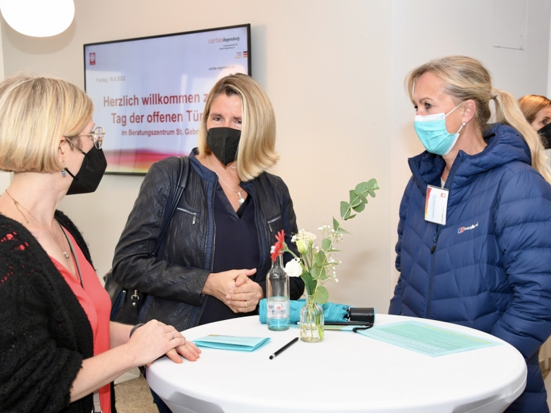 Drei Personen an Stehtisch