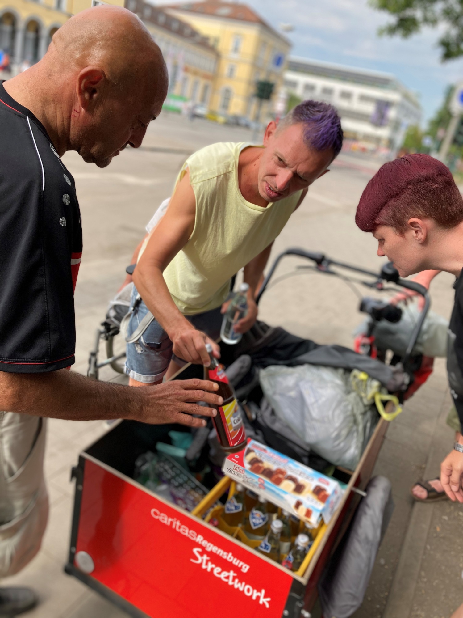 Drei Personen mit Lastenrad
