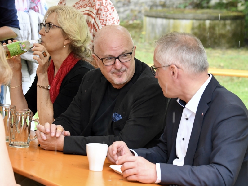 Personen im Garten an Bierb&auml;nken