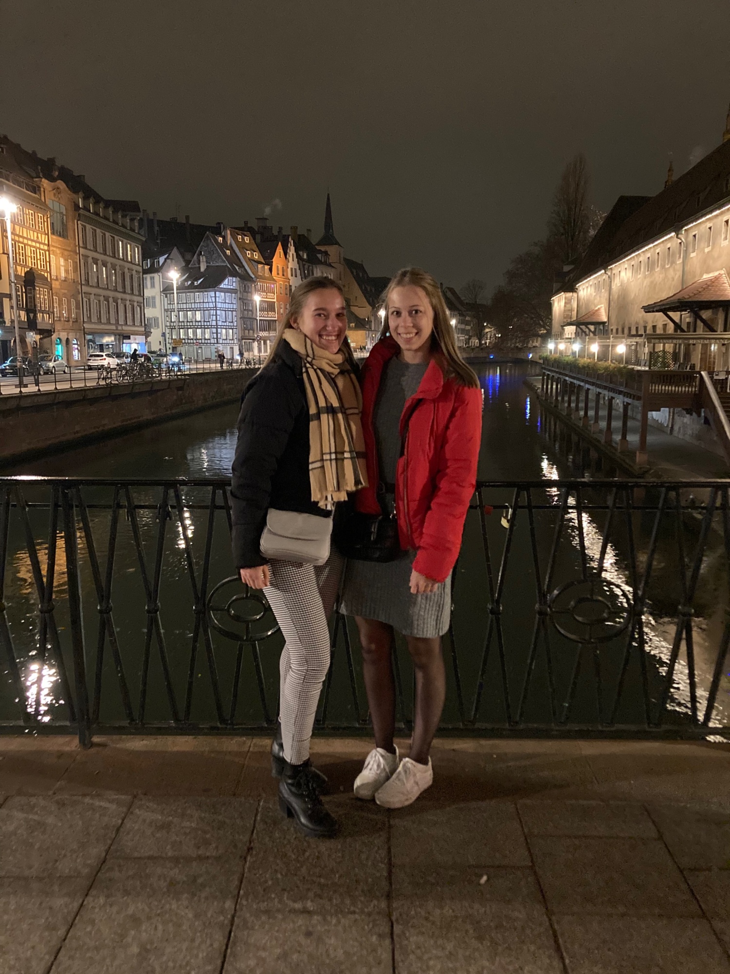 Zwei Personen auf Brücke bei Nacht vor Kanal.