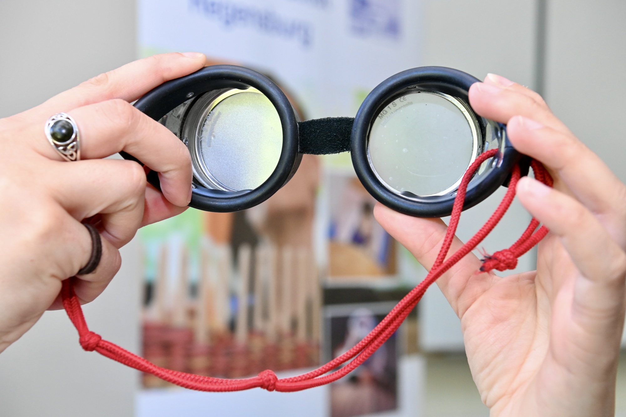 Besondere Brille vor Plakat