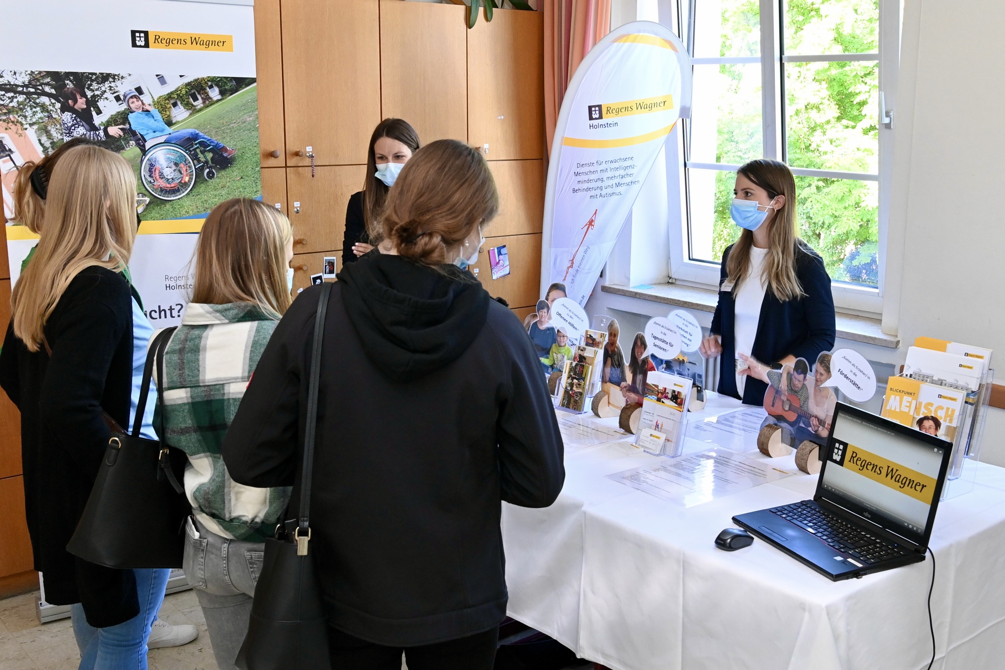 Personen an einem Messestand