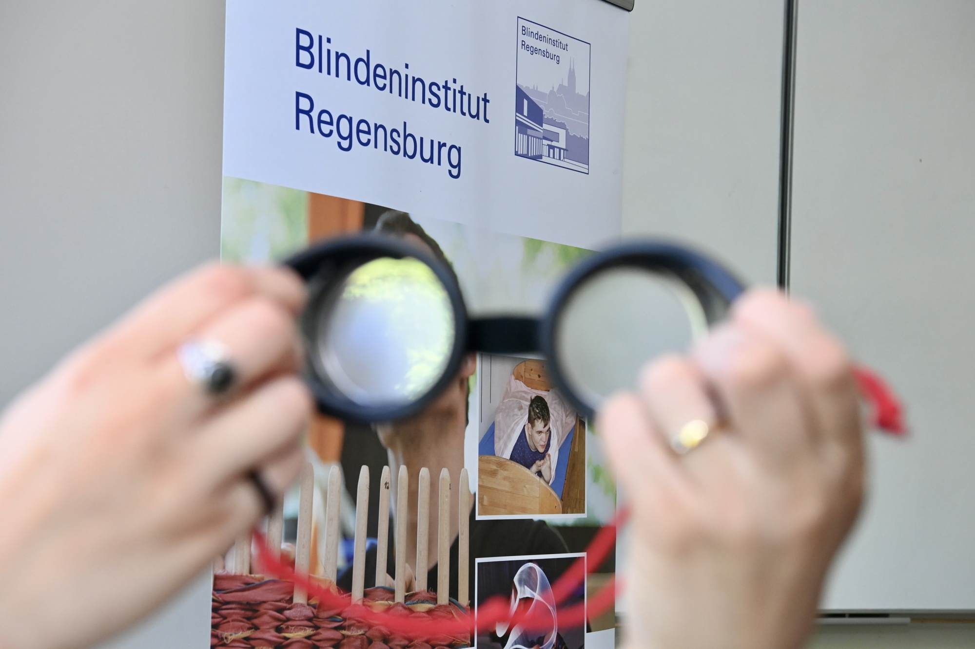 Besondere Brille vor Plakat