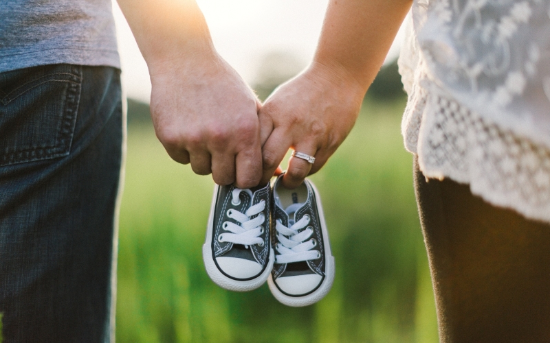 Zwei Personen halten Kinderschuhe in der Hand